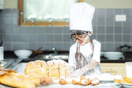 Lifestyle Family. Smiling chef asian kid boy cooking toast and make  bread for dinner.  People...