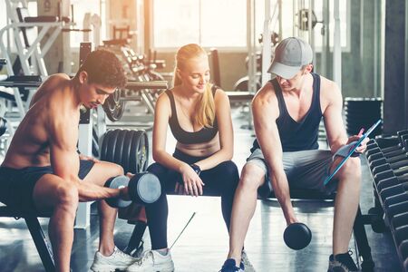Trainer training exercise with man and woman at the gym for healthy care and body slim.  Fitness instructor exercising with his client people the fitness. Diet and Healthy sport Conceptの写真素材
