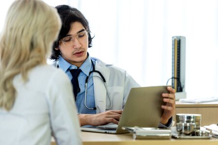 Doctor talking and discussing something with patient in the hospitalの写真素材