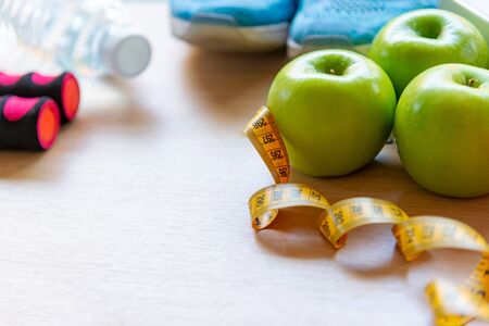 Diet and Healthy life loss weight Concept. Green apple and Weight scale measure tap with fresh vegetable and sport equipment for women diet slimmingの写真素材