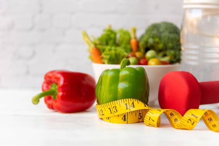 Diet Health food and lifestyle health concept. Sport exercise equipment workoutÂ andÂ gym background with fresh salad and measuring tap for fitness style stay at home. Healthy Lifestyle Conceptの写真素材