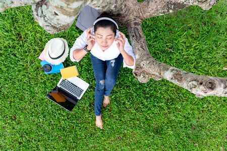 Lifestyle people girl relax reading book and listening music and work from home with laptop on the...