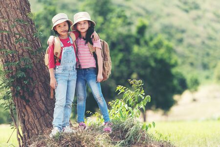 Group asian family children raise arms and standing see the outdoors, adventure and tourism for destination and leisure trips with mountain for education and relax in nature park.Â  Travel vacations and Life Conceptの写真素材