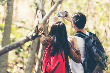 Tourist and traveler asian couple backpack enjoy happy take a photo selfie in the jungle forest...