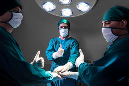 Group Surgeon doctor consent after Patient surgery in hospital operating theater .   Teamwork...