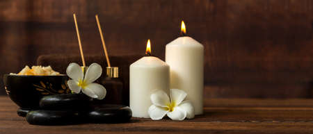 Thai spa composition treatments aroma therapy with candles and Plumeria flowers on wooden table. Healthy and Relax Conceptの写真素材
