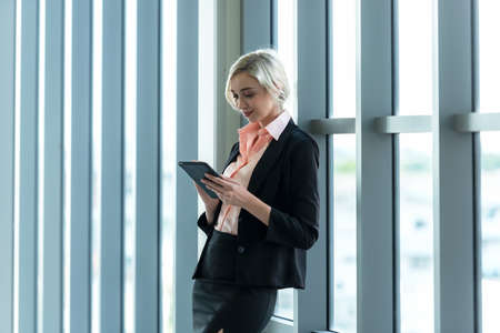 Business women using tablet computer to work with financial data in the modern office, relax and rest time after work.  Business Concept.の写真素材