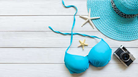 Summer items and accessories traveler woman,  blue bikini, big hat and camera go to travel plan holiday vacation in the beach. Tropical sea. Unusual top view, banner and copt space. Travel and Summertime Concept.の写真素材