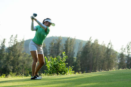 Golfer sport approach on course golf ball fairway.Â  People lifestyle woman playing game golf tee of on the green grass background.Â  Asia female player game shot in summer.Â  Healthy and Sport outdoorの写真素材