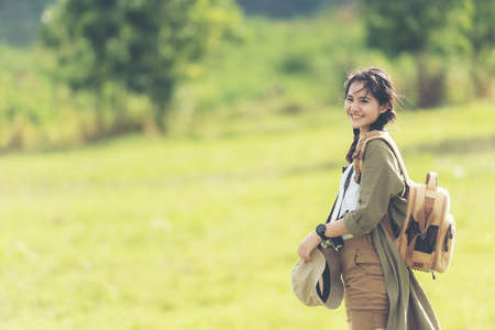Asian young woman holding camera and standing in the jungle adventure.  Tourism for destination and leisure trips for education and relax in nature park.  Travel vacations and Lifestyle Conceptの写真素材