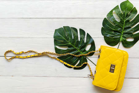 Fashion bag  woman accessories wood white background. Trendy fashion luxury yellow handbag design...