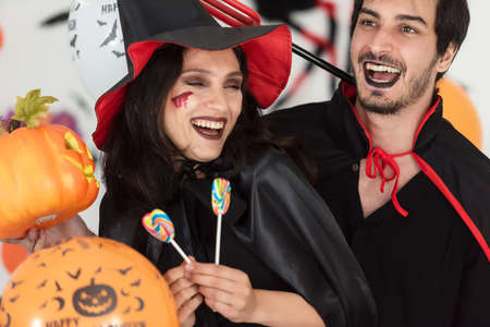 Party Halloween holiday.  Young couple party and celebrate with Halloween pumpkin and cocktails with...