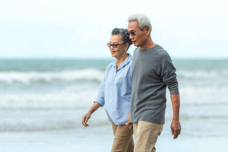 Lifestyle asian senior couple happy walking and relax on the beach.  Tourism elderly family travel leisure and activity after retirement in vacations and summer.の写真素材