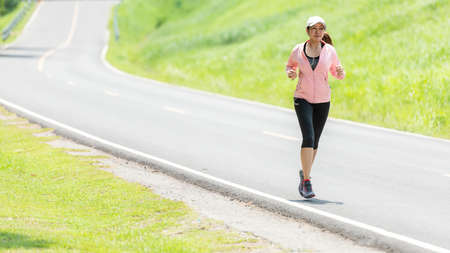 Healthy woman jogging run and workout on road outdoor. Asian runner people exercise gym with fitness...