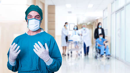 Surgeon man doctor we are mask and grove protection coronavirus.  Team Medical personnel and patients for discussion at hospital clinic room background.   Teamwork medical doctor working clinical treatment and protection virus.の写真素材