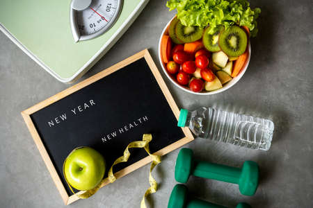 New Year for New Healthy 2021.  Fresh vegetable salad and healthy food for sport equipment for women diet slimming weight loss background. Healthy change new life Conceptの写真素材