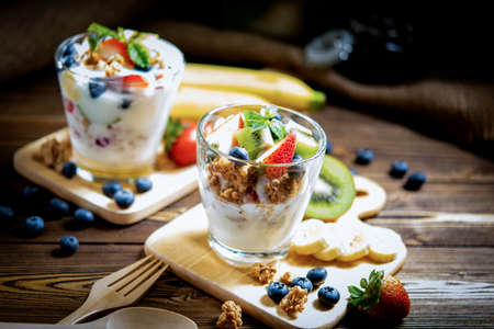 Fresh fruit yoghurt and mix fruit for healthy and dieting.  Health care people with smoothie drink of on the wood backgroundの写真素材