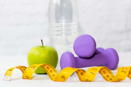 Diet Health food and lifestyle health concept. Sport exercise equipment workout Â and gym background with green apple and measuring tap for fitness style. Healthy Lifestyle Conceptの写真素材