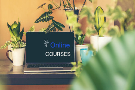 Course Online text on laptop screen on table with plant and coffee cup in the nature garden at home. Technology and Education Conceptの写真素材