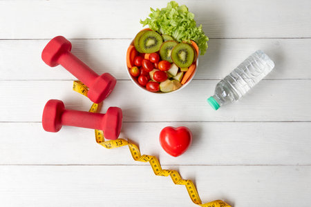 Diet Healthy food and lifestyle health concept. Sport exercise equipment workoutÂ andÂ gym background with nutrition detox salad for fitness style. Health care Conceptの写真素材