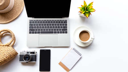 Traveler planning vacation trip and searching tourist attraction and information or booking hotel on laptop with accessories item women and map, old camera.  Top view and white background.  Travel conceptの写真素材