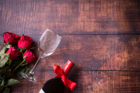 Valentine Day.  Red wine and red rose on old wood background.  Holiday and Valentine Concept.の写真素材