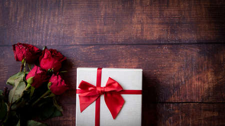 Valentine day.  Red Rose with gift box and  valentine card on old wood background.  Lover heart romantic in valentine day.  Holiday and Valentine Conceptの写真素材