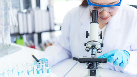 select focus. Scientists analyzing study data and evaluating microscope success for work shop. Health care researchers doing some research with dropper chemical testing in life science laboratory.の写真素材