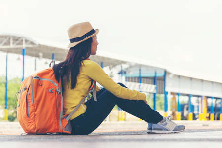 Asia young women traveler and tourist traveling backpack holding map and waiting in a train station...