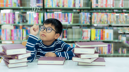 Asia schoolboy thinking good idea after reading books for education and go to school in library. Education and Lifestyle Conceptの写真素材
