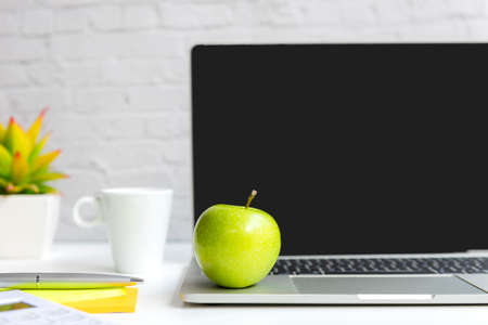 Healthy snack with working in office.  Green apple with laptop on white dress working.  Healthy Lifestyle Conceptの写真素材