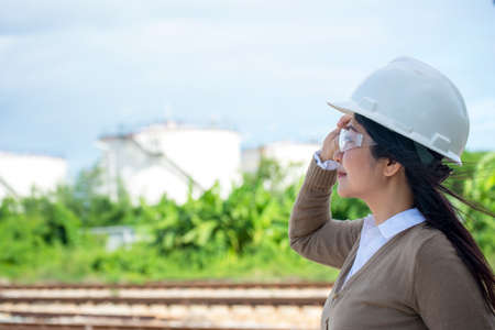 Engineers woman holding blueprint and report schedule for workers security control at power plant energy industry. Engineer and industry Conceptの写真素材
