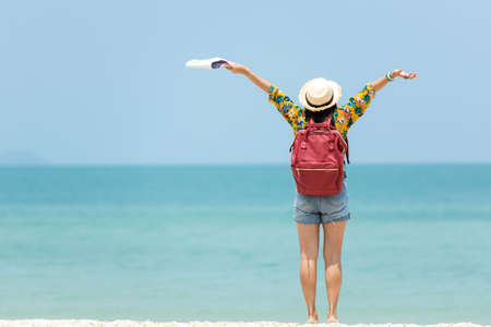 Happy traveler and tourism women travel summer on the beach.Â  Asia people holding map and raise arm planning travel trip and relax outdoor for destination and leisure.Â  Summer Vacation Travel Conceptの写真素材