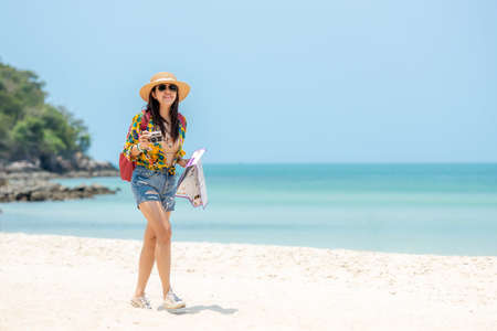 Happy traveler and tourism women travel summer on the beach.Â  Asia smiling people holding map and camera planning travel trip and relax outdoor for destination and leisure.Â  Summer Vacation Travel Conceptの写真素材