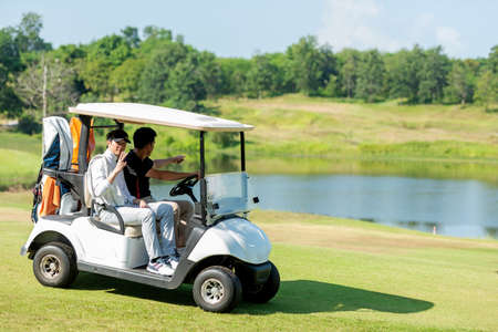 Group Golfer asian man and friend sitting on the car golf go to golf course shot continue game.  Hobby in holiday and vacations in sunny morning day on club golf. Lifestyle and Sport Conceptの写真素材