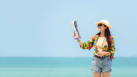 Happy traveler and tourism women travel summer on the beach.Â  Asian smiling people holding map and camera planning travel trip and relax outdoor for destination and leisure.Â  Summer Vacation Travel Conceptの写真素材