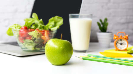 Healthy snack with working in office.  Close up Green apple for diet Health Plan on white  table working, fresh salad and laptop background.  Healthy Lifestyle Conceptの写真素材