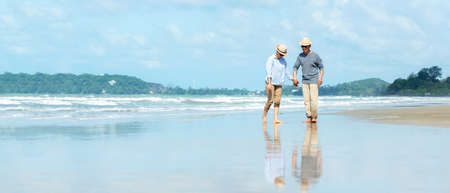 Asian Lifestyle senior couple walking chill on the beach happy in love romantic and relax time after retirement.Â  People tourism elderly family travel leisure and activity after retirement in vacations and summer. copy space for bannerの写真素材