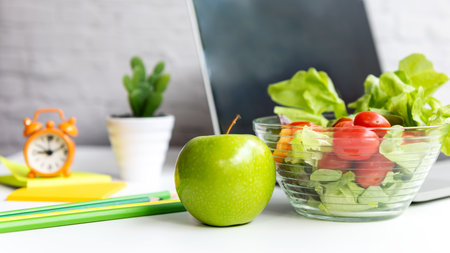 Healthy snack with working in office.  Green apple and fresh salad with water for diet Health Plan with laptop on white dress working.  Healthy Lifestyle Conceptの写真素材