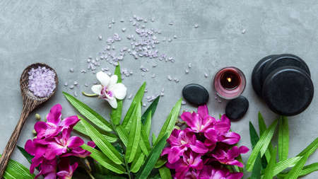 Thai Spa. Top view of hot stones setting for massage treatment and relax with purple orchid on blackboard with copy space. Green leaf with black stones pile for spa therapy. Lifestyle Healthyの写真素材
