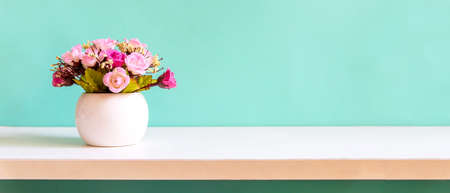 Green wall with flower on shelf white wood for interior at home. copy space for banner text. Still life and Lifestyle Conceptの写真素材