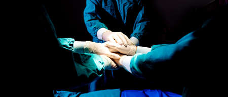 Close up hands team of medical workers holding hands together in hospital.  Group doctor coordinate...