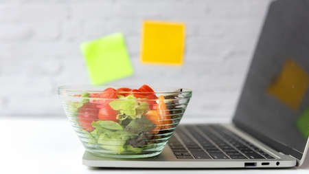 Healthy working in office.  Fresh vegetable salad with water for diet Health Plan with laptop on white dress working.  Healthy eat for working in office.   Healthy Lifestyle Conceptの写真素材