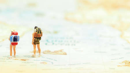 Miniature Group traveler with backpack standing on wold map for travel around the world. Travel Conceptの写真素材