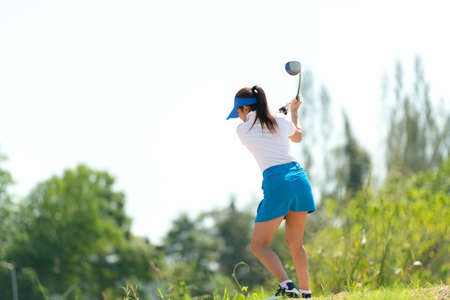 Golfer sport approach on course golf ball fairway.Â  People lifestyle woman playing game golf tee of on the green grass.Â  Asia female player game shot in summer.Â  Healthy and Sport outdoorの写真素材