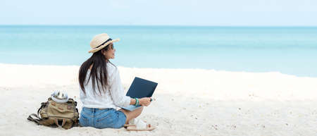 Lifestyle freelance woman using laptop working and relax on the beach.Â  Asian people success and together your work pastime and meeting conference on internet in holiday. Business and Summer Concept, copy space for bannerの写真素材