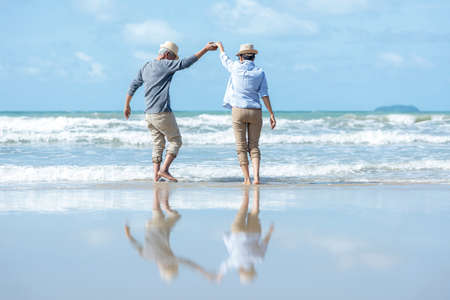 Retirement Travel. Asian Lifestyle senior couple dancing on the beach happy and relax time.  Tourism elderly family travel leisure and activity after retirement in vacations and summer.の写真素材