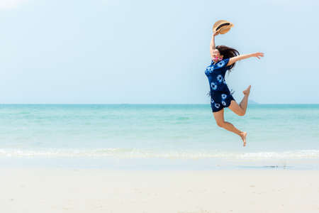 Summer vacations. Lifestyle woman relax and chill on beach background.  Asia happy young people jumping on the wave sea, summer trips walking enjoy tropical beach. Lifestyle and Travel Conceptの写真素材