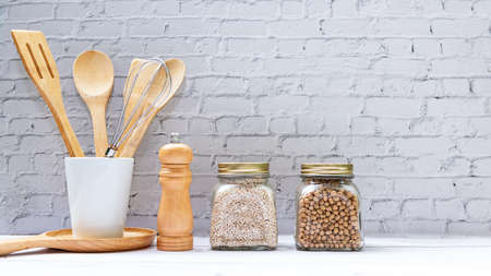 Kitchen tools and kitchenware utensil object with ingredients and mix nut on kitchen shelf wood white for healthy eat and health care life.  Wall white brick background, copy space for textの写真素材