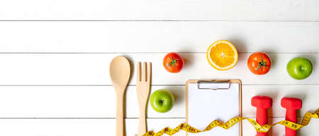 Planning for Diet Health eat and food.  Sport exercise equipment workout with fresh fruit, measuring tap, note pad for fitness style. Nutrition Healthy Lifestyle Concept, Top view and copy spaceの写真素材